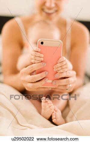 Baby girl and mother's hands gripping smartphone, close up View Large Photo Image Stock Image - Baby girl and mother's hands gripping smartphone, close up. Fotosearch