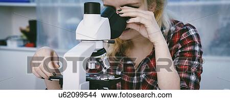 Picture - Biology lesson. Student using a light microscope.. Fotosearch