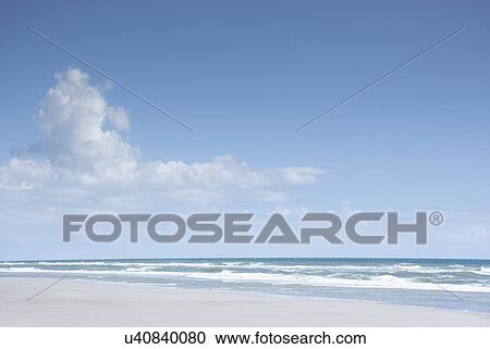 Stock Image - Blue sky and clouds above sea. Fotosearch