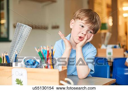 Bored primary schoolboy at classroom desk View Large Photo Image Picture - Bored primary schoolboy at classroom desk. Fotosearch