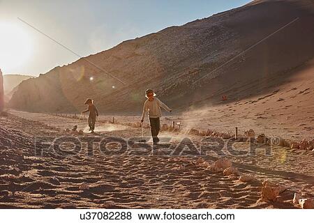 Boy and his brother pulling toy trucks along desert path, Atacama, Chile View Large Photo Image Stock Photo - Boy and his brother pulling toy trucks along desert path, Atacama, Chile. Fotosearch