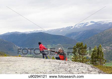 Boy helping hiker father over rock in mountain landscape, Jotunheimen National Park, Lom, Oppland, Norway View Large Photo Image Stock Image - Boy helping hiker father over rock in mountain landscape, Jotunheimen National Park, Lom, Oppland, Norway. Fotosearch