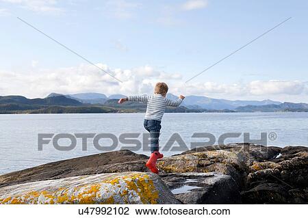 Boy jumping rocks by fjord, Aure, More og Romsdal, Norway View Large Photo Image Stock Image - Boy jumping rocks by fjord, Aure, More og Romsdal, Norway. Fotosearch