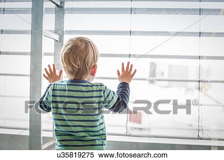 Stock Photography - Boy looking out of window. Fotosearch
