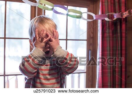 Stock Image - Boy playing hide and seek. Fotosearch