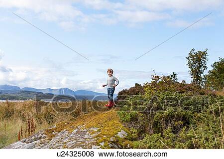Boy playing on rock near fjord, Aure, More og Romsdal, Norway View Large Photo Image Stock Photo - Boy playing on rock near fjord, Aure, More og Romsdal, Norway. Fotosearch