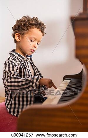 Boy playing piano View Large Photo Image Stock Photo - Boy playing piano. Fotosearch