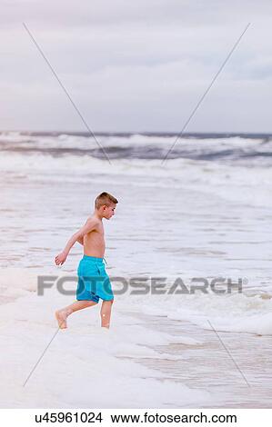 Picture - Boy running into sea, Dauphin Island, Alabama, USA. Fotosearch