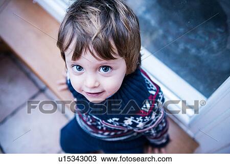 Boy sitting by patio door View Large Photo Image Stock Image - Boy sitting by patio door. Fotosearch