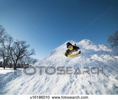 Boy sledding on snow View Large Photo Image Stock Image - Boy sledding on snow. Fotosearch