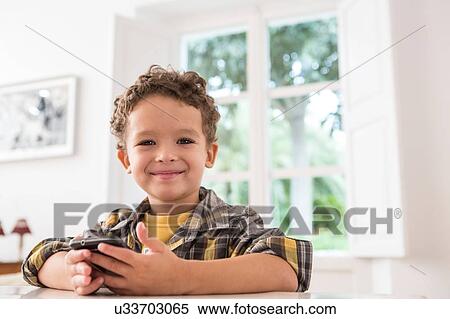 Boy using mobile phone View Large Photo Image Stock Photography - Boy using mobile phone. Fotosearch