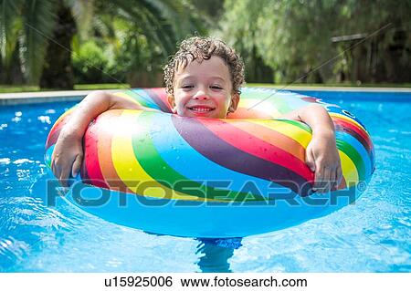 Boy with inflatable ring in outdoor swimming pool, portrait View Large Photo Image Stock Photograph - Boy with inflatable ring in outdoor swimming pool, portrait. Fotosearch