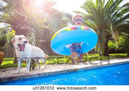Boy with inflatable ring on poolside with golden retriever, portrait View Large Photo Image Stock Image - Boy with inflatable ring on poolside with golden retriever, portrait. Fotosearch