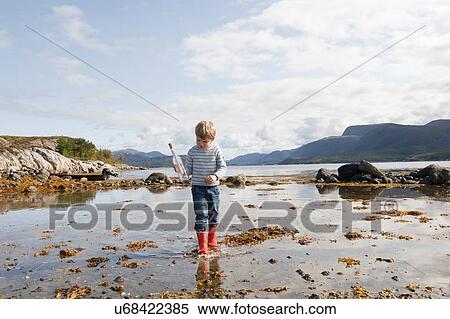 Stock Photography - Boy with message in a bottle, Aure, More og Romsdal, Norway. Fotosearch