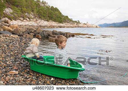 Boys in green boat at fjord water's edge, Aure, More og Romsdal, Norway View Large Photo Image Stock Image - Boys in green boat at fjord water's edge, Aure, More og Romsdal, Norway. Fotosearch
