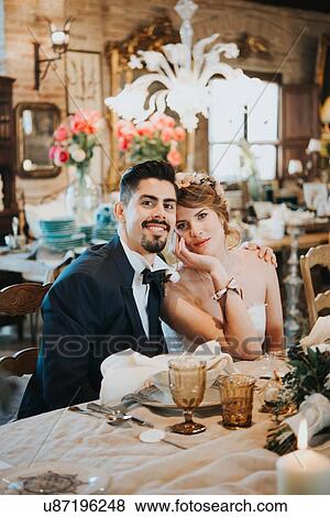 Bride and bridegroom seated at table at wedding reception View Large Photo Image Stock Photo - Bride and bridegroom seated at table at wedding reception. Fotosearch