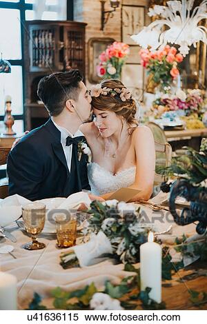 Stock Photography - Bride and bridegroom seated at table at wedding reception. Fotosearch