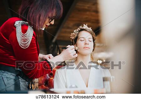 Picture - Bride preparing for wedding with make-up artist. Fotosearch