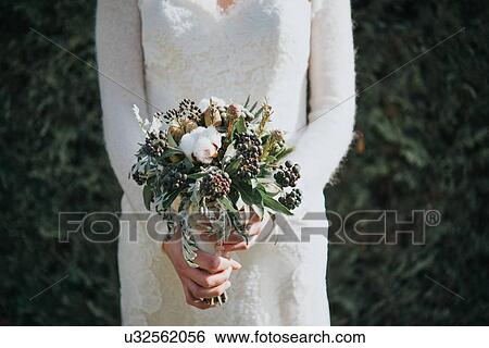 Bride with wedding bouquet, hedge in background View Large Photo Image Stock Photograph - Bride with wedding bouquet, hedge in background. Fotosearch