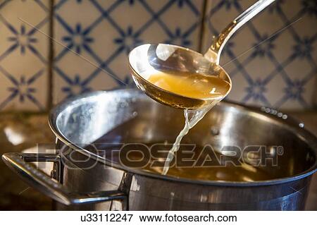 Broth being ladled from saucepan View Large Photo Image Stock Photo - Broth being ladled from saucepan. Fotosearch