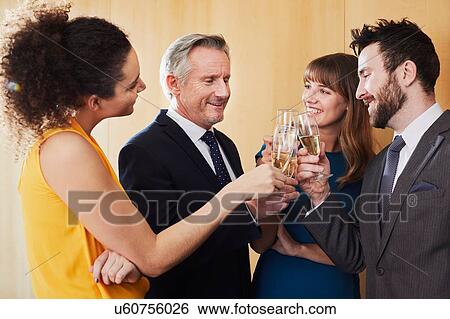 Business team raising champagne toast at office celebration View Large Photo Image Stock Photograph - Business team raising champagne toast at office celebration. Fotosearch