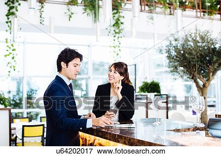 Businessman and businesswoman having drink at bar View Large Photo Image Stock Photo - Businessman and businesswoman having drink at bar. Fotosearch
