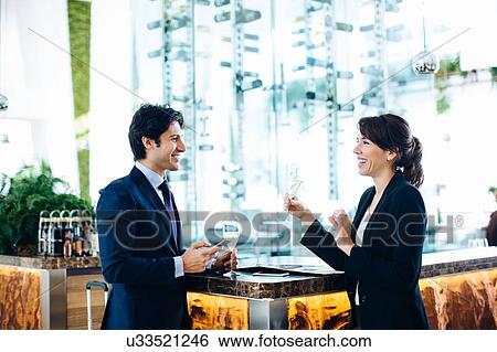 Businessman and businesswoman having drink at bar View Large Photo Image Stock Photograph - Businessman and businesswoman having drink at bar. Fotosearch