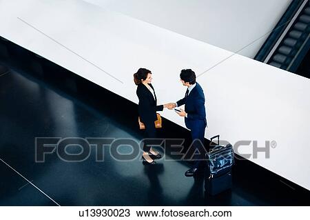 Businessman and businesswoman with wheeled luggage in hotel building View Large Photo Image Stock Image - Businessman and businesswoman with wheeled luggage in hotel building. Fotosearch