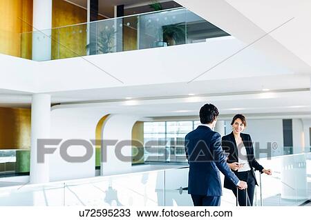 Businessman and businesswoman with wheeled luggage in hotel building View Large Photo Image Stock Image - Businessman and businesswoman with wheeled luggage in hotel building. Fotosearch