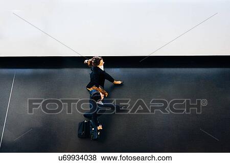 Businessman and businesswoman with wheeled luggage in hotel building View Large Photo Image Stock Photo - Businessman and businesswoman with wheeled luggage in hotel building. Fotosearch