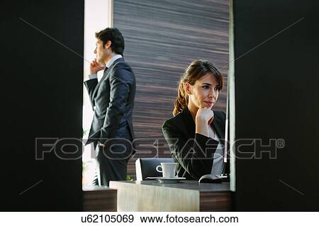 Stock Photo - Businessman and businesswoman working in hotel bedroom. Fotosearch