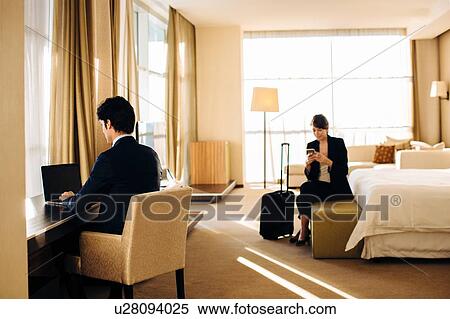 Businessman and businesswoman working in hotel bedroom View Large Photo Image Stock Photography - Businessman and businesswoman working in hotel bedroom. Fotosearch