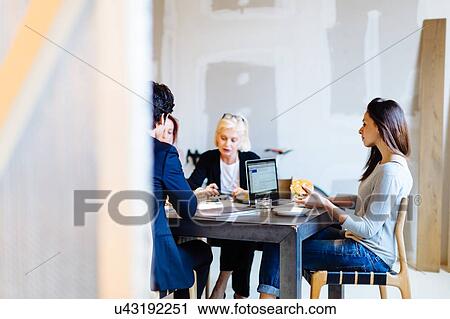 Businessman and women sitting at table in meeting View Large Photo Image Stock Image - Businessman and women sitting at table in meeting. Fotosearch