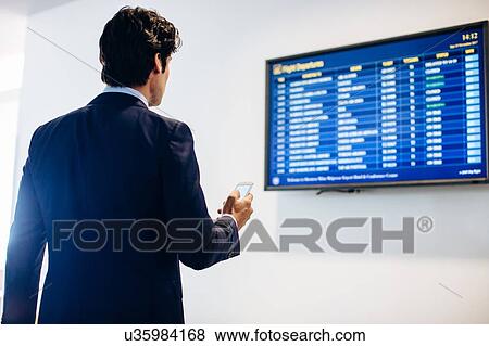 Businessman checking departure board View Large Photo Image Stock Photo - Businessman checking departure board. Fotosearch