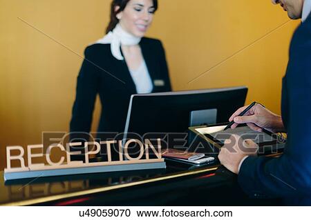 Businessman checking in at hotel reception View Large Photo Image Stock Image - Businessman checking in at hotel reception. Fotosearch
