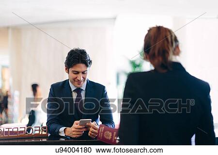 Businessman checking in at hotel reception View Large Photo Image Stock Image - Businessman checking in at hotel reception. Fotosearch