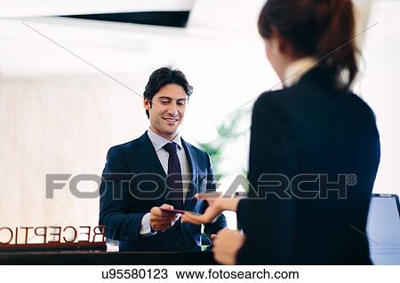 Businessman checking in at hotel reception View Large Photo Image Stock Image - Businessman checking in at hotel reception. Fotosearch
