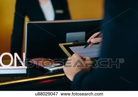 Businessman checking in at hotel reception View Large Photo Image Stock Photo - Businessman checking in at hotel reception. Fotosearch
