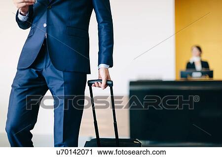 Businessman checking out of hotel View Large Photo Image Stock Image - Businessman checking out of hotel. Fotosearch