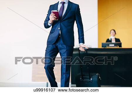 Businessman checking out of hotel View Large Photo Image Stock Photo - Businessman checking out of hotel. Fotosearch