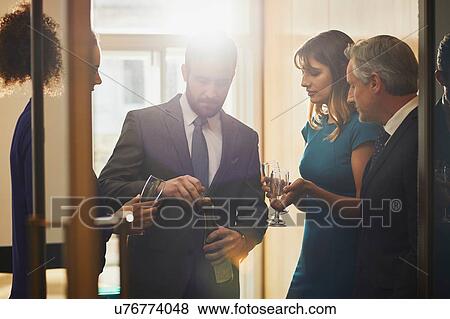 Businessman opening champagne at office celebration View Large Photo Image Stock Photo - Businessman opening champagne at office celebration. Fotosearch