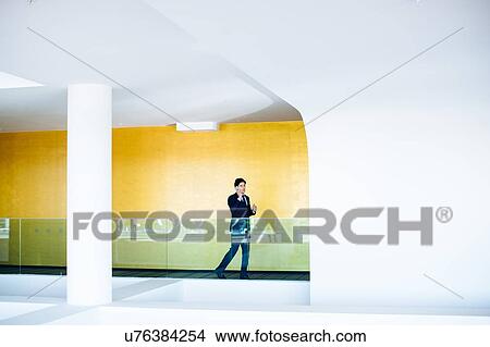 Picture - Businessman using mobile phone in hotel building. Fotosearch