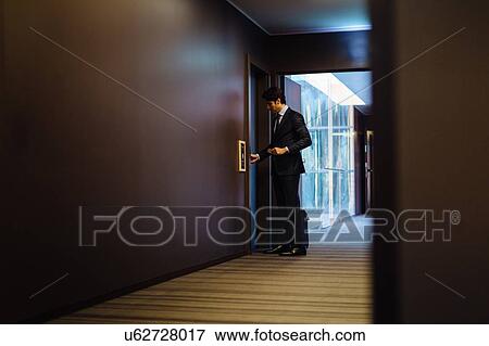 Businessman with wheeled luggage entering hotel bedroom View Large Photo Image Stock Photo - Businessman with wheeled luggage entering hotel bedroom. Fotosearch