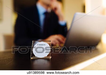 Stock Photo - Businessman working in business centre in hotel. Fotosearch