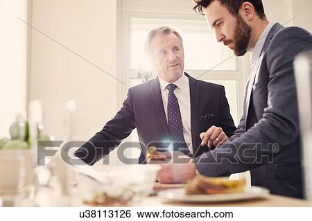 Businessmen meeting over working lunch View Large Photo Image Stock Photograph - Businessmen meeting over working lunch. Fotosearch