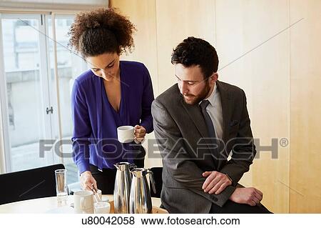 Businesswoman and man taking a coffee break during office meeting View Large Photo Image Stock Photo - Businesswoman and man taking a coffee break during office meeting. Fotosearch
