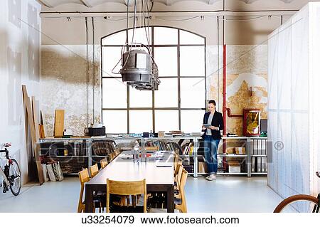 Stock Photo - Businesswoman standing in modern office. Fotosearch