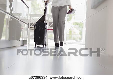 Picture - Businesswoman walking with suitcase. Fotosearch