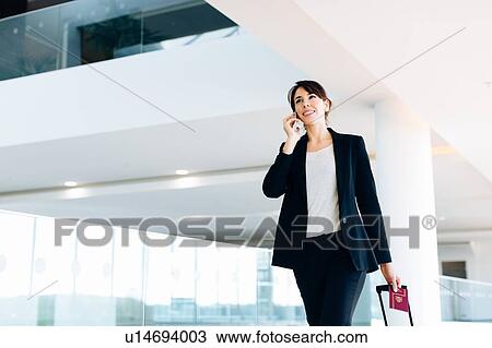 Businesswoman with wheeled luggage in hotel building View Large Photo Image Stock Image - Businesswoman with wheeled luggage in hotel building. Fotosearch