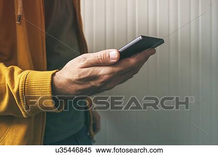 Stock Photography - Casual young adult man using mobile phone.. Fotosearch